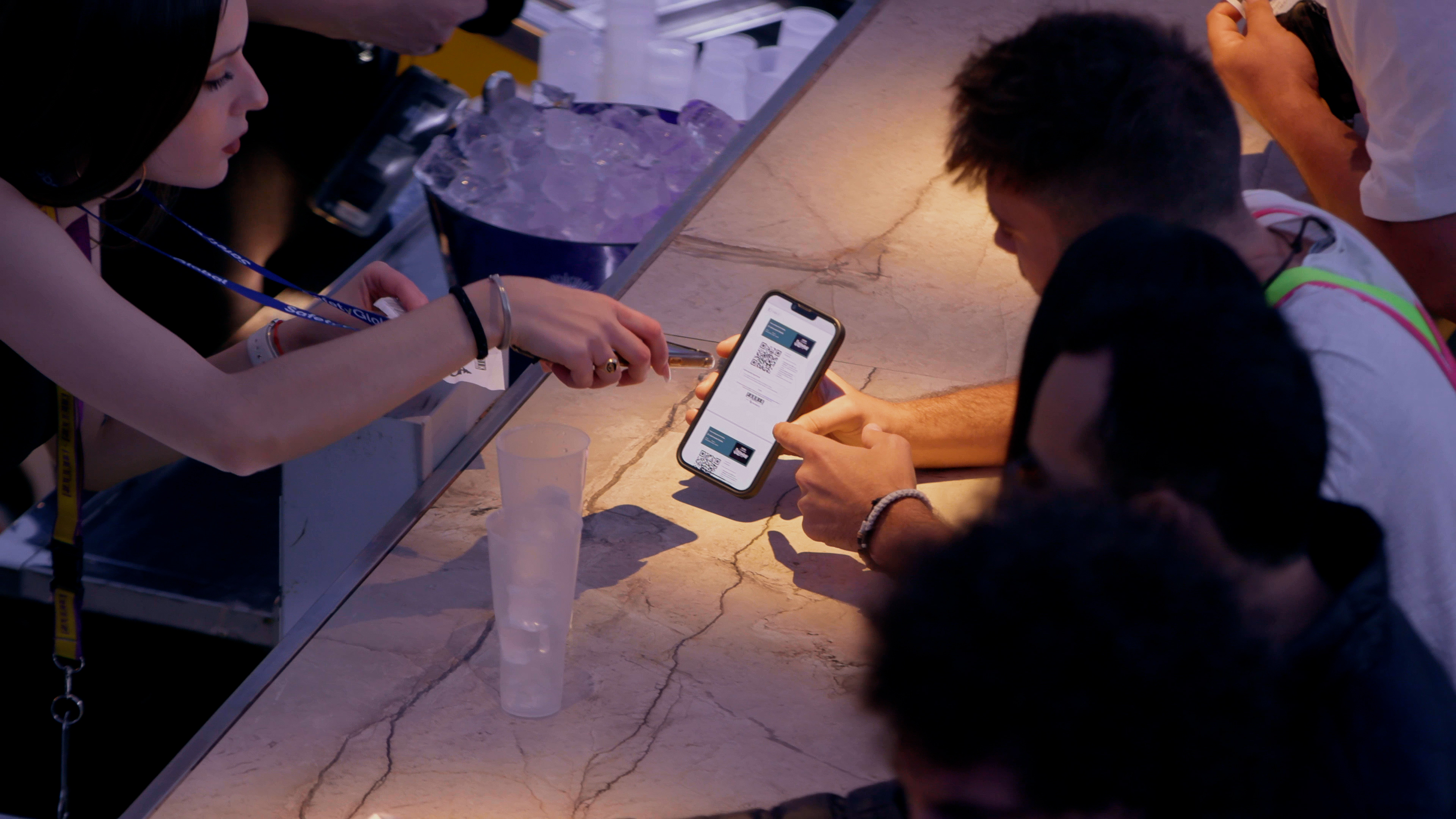 A bartender scanner a QR code at a bar